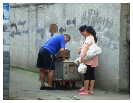 People buy steamed buns from street in China.